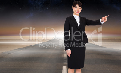 Composite image of smiling businesswoman pointing