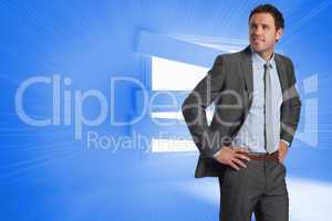 Composite image of smiling businessman with hands on hips