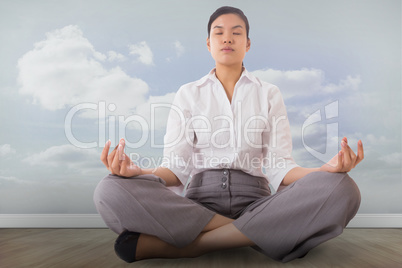 Composite image of businesswoman sitting in lotus pose