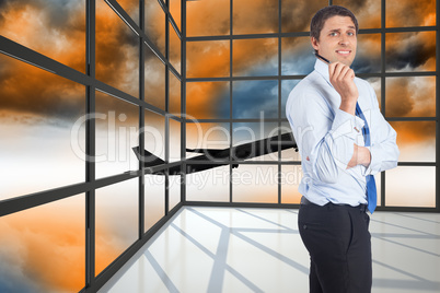 Composite image of thinking businessman holding pen