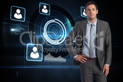 Composite image of serious businessman with hand on hip