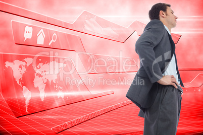 Composite image of stern businessman standing with hands on hips