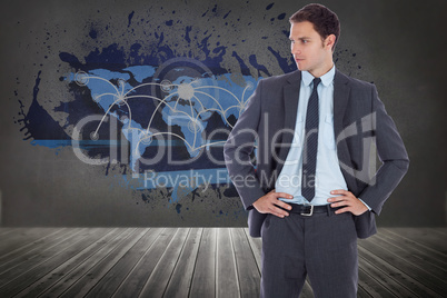 Composite image of serious businessman with hands on hips