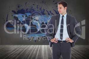 Composite image of serious businessman with hands on hips