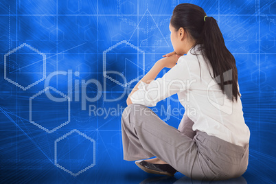 Composite image of businesswoman sitting cross legged