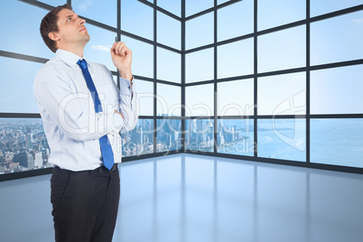 Composite image of thinking businessman holding pen