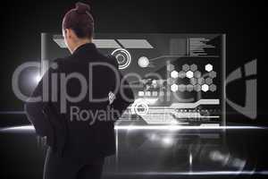 Composite image of businesswoman with hands on hips