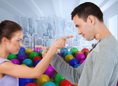 Composite image of young couple pointing at each other