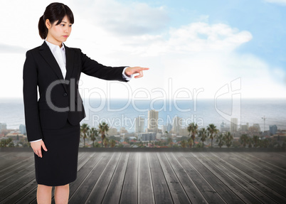 Composite image of focused businesswoman pointing