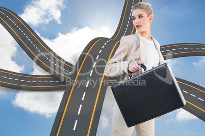 Composite image of serious elegant businesswoman holding briefca Composite image of serious elegant businesswoman holding briefca