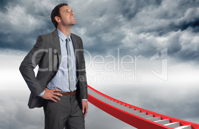 Composite image of smiling businessman with hand on hip