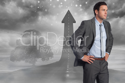 Composite image of serious businessman with hands on hips