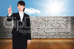 Composite image of focused businesswoman pointing