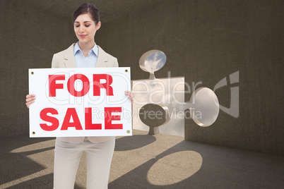 Composite image of estate agent holding for sale sign