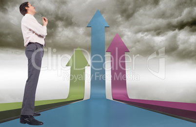 Composite image of thinking businessman holding pen