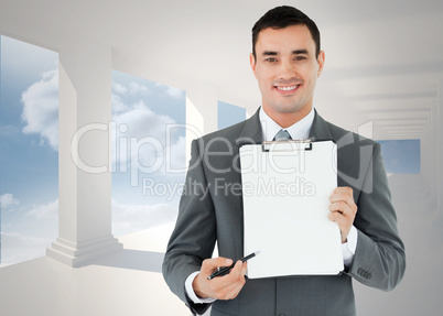 Composite image of businessman pointing with pen on clipboard