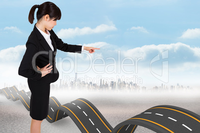 Composite image of focused businesswoman pointing