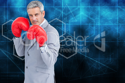 Composite image of tough businessman with boxing gloves