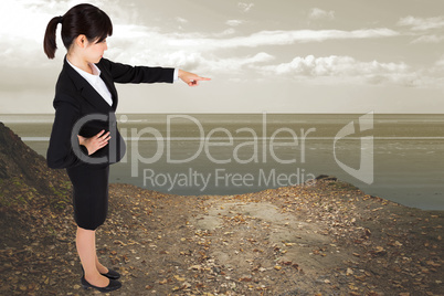 Composite image of focused businesswoman pointing