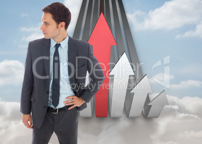 Composite image of serious businessman standing with hand on hip