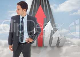 Composite image of serious businessman standing with hand on hip