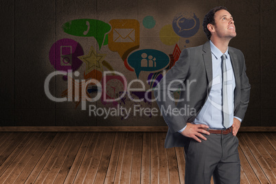 Composite image of smiling businessman with hands on hips