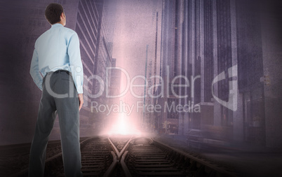 Composite image of businessman standing with hand in pockets