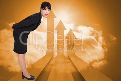 Composite image of surpised businesswoman bending