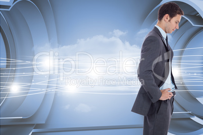 Composite image of serious businessman with hands on hips