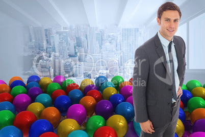 Composite image of cheerful businessman standing with hand on hi