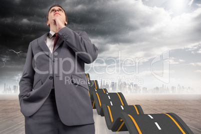 Composite image of thoughtful businessman with hand on chin