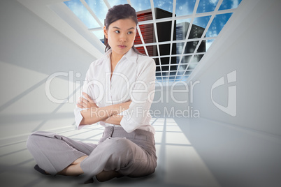 Composite image of annoyed businesswoman sitting with arms cross