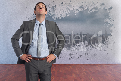 Composite image of serious businessman with hands on hips