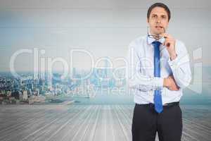 Composite image of thinking businessman biting glasses