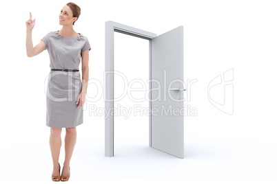Composite image of smiling woman in a dress pointing upwards