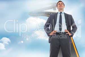 Composite image of happy businessman with hands on hips