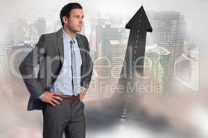 Composite image of serious businessman with hands on hips