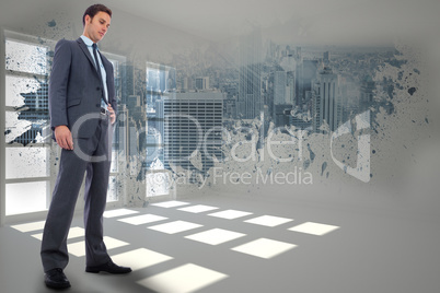 Composite image of serious businessman with hand on hip