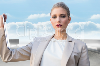 Composite image of serious classy businesswoman holding tablet