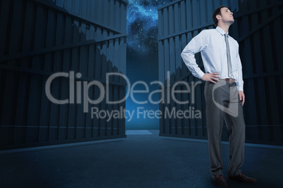 Composite image of serious businessman with hand on hip