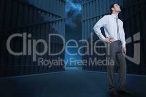 Composite image of serious businessman with hand on hip