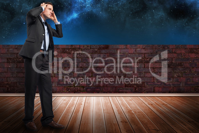 Composite image of stressed businessman with hands on head