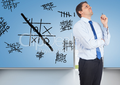 Composite image of thinking businessman holding pen