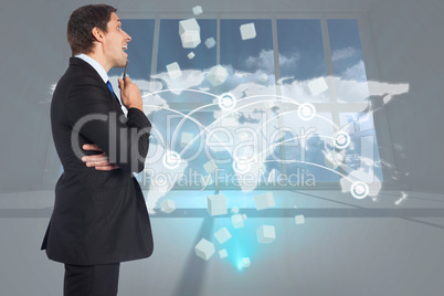 Composite image of thinking businessman holding pen