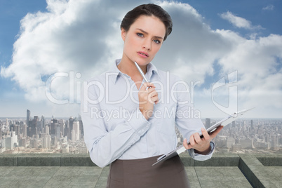 Composite image of elegant young businesswoman with clipboard