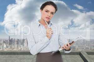 Composite image of elegant young businesswoman with clipboard
