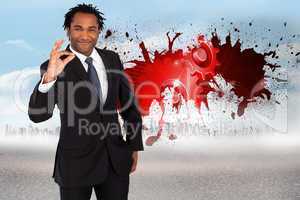 Composite image of businessman showing okay sign