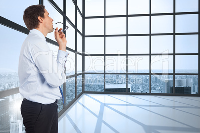 Composite image of thinking businessman biting glasses