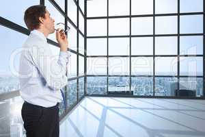 Composite image of thinking businessman biting glasses