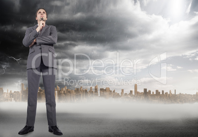 Composite image of thinking businessman holding glasses